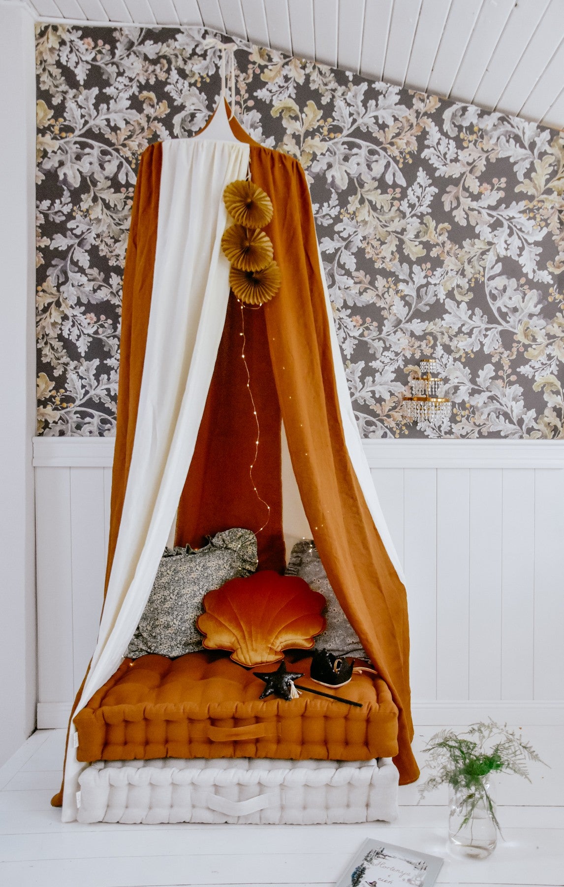 organic cotton and linen canopy in warm caramel tones, hung over a child's bed with soft morning light