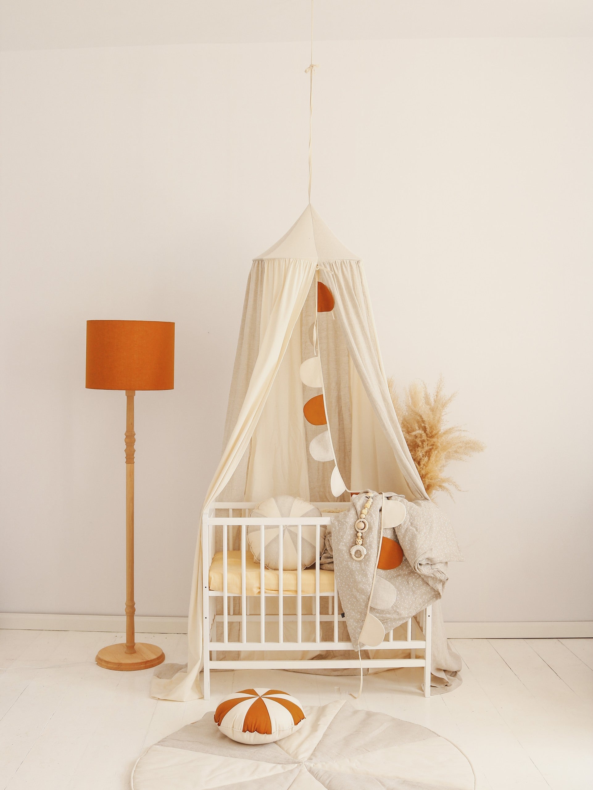 soft cream cotton and linen canopy hanging gently over a cozy reading nook with warm natural light