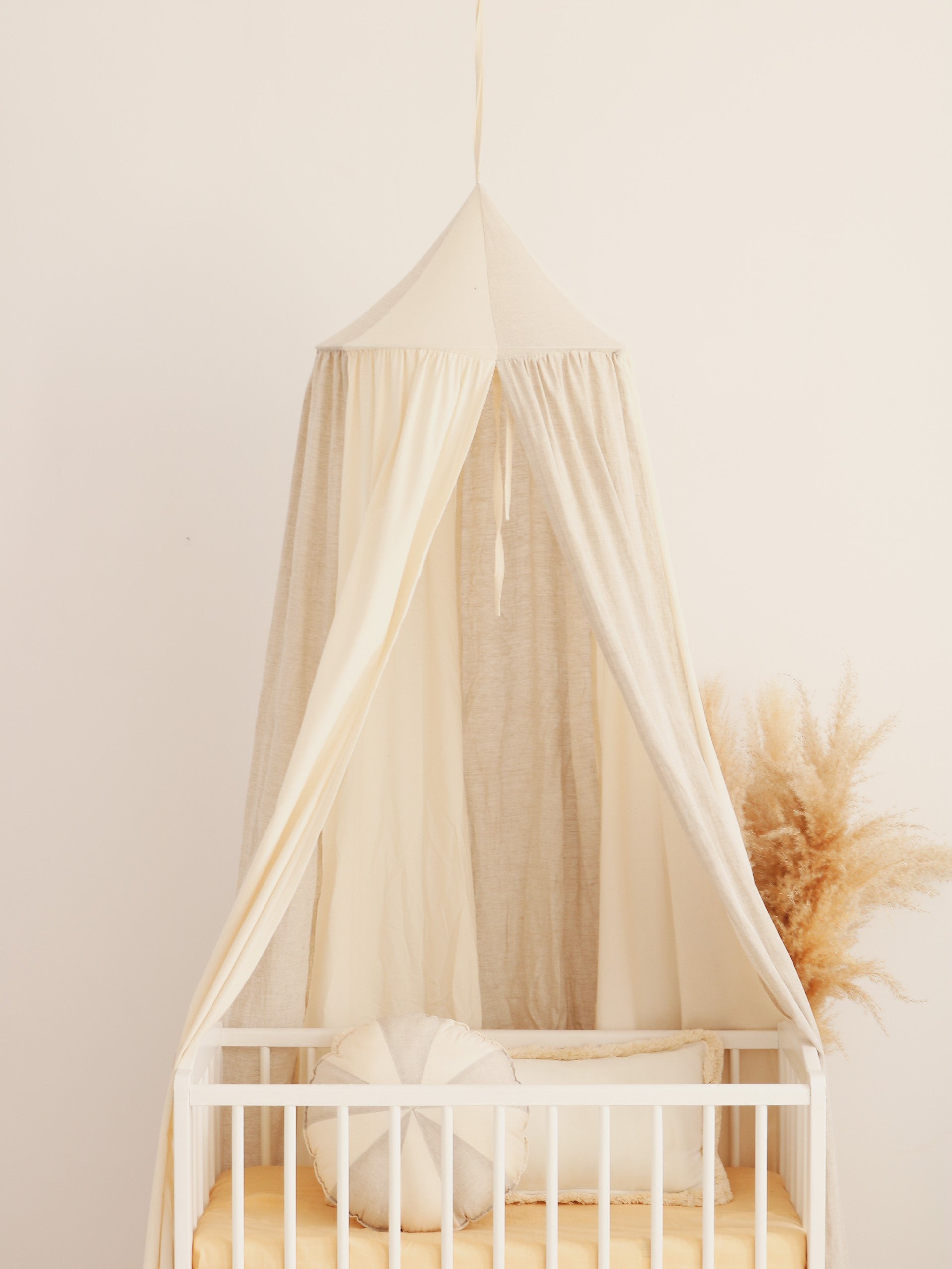cream circus organic cotton and linen canopy hanging over a cozy reading nook with soft natural light