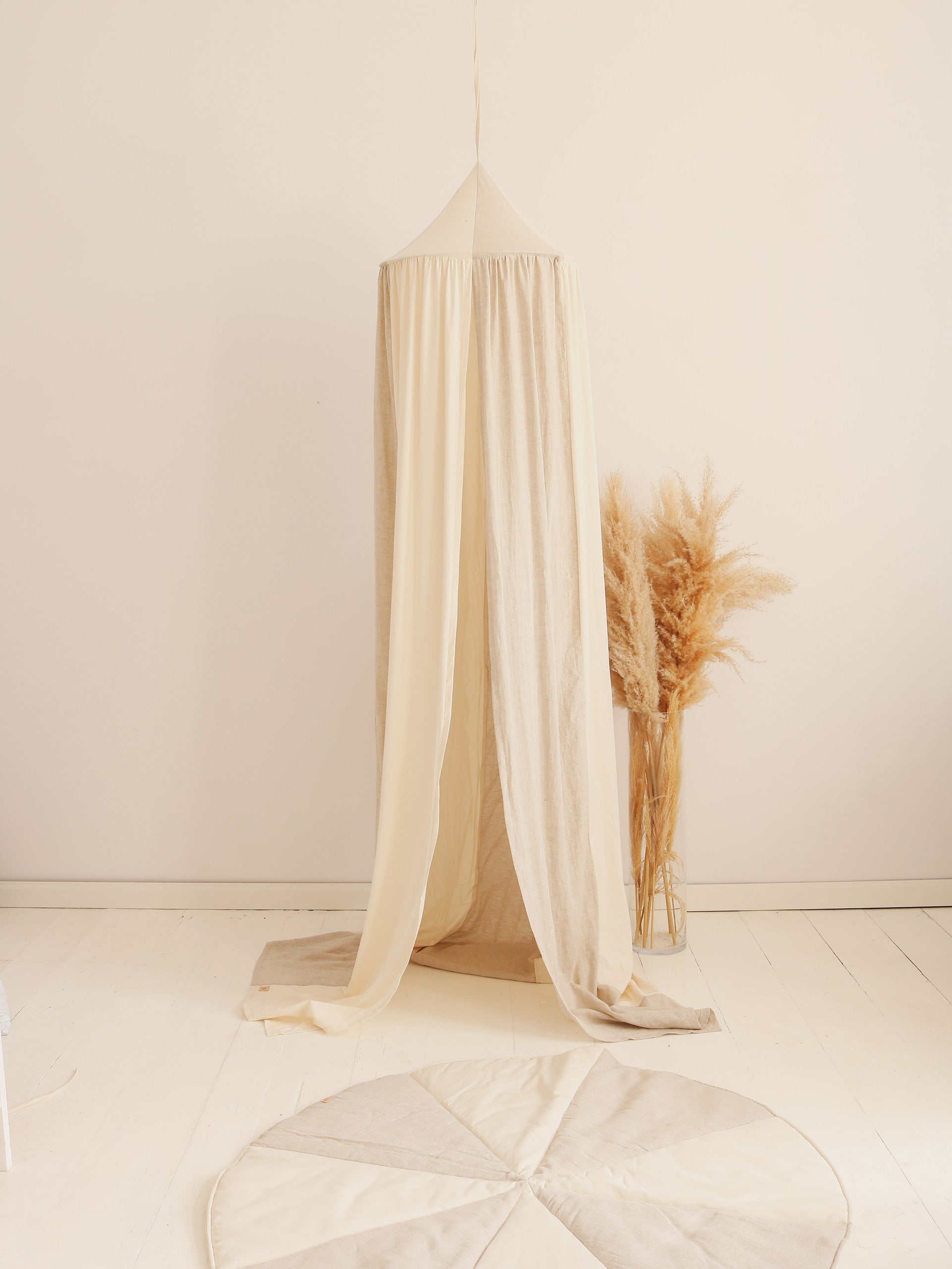 artisan-made cream and grey cotton linen canopy hanging over a child's bed with soft morning light