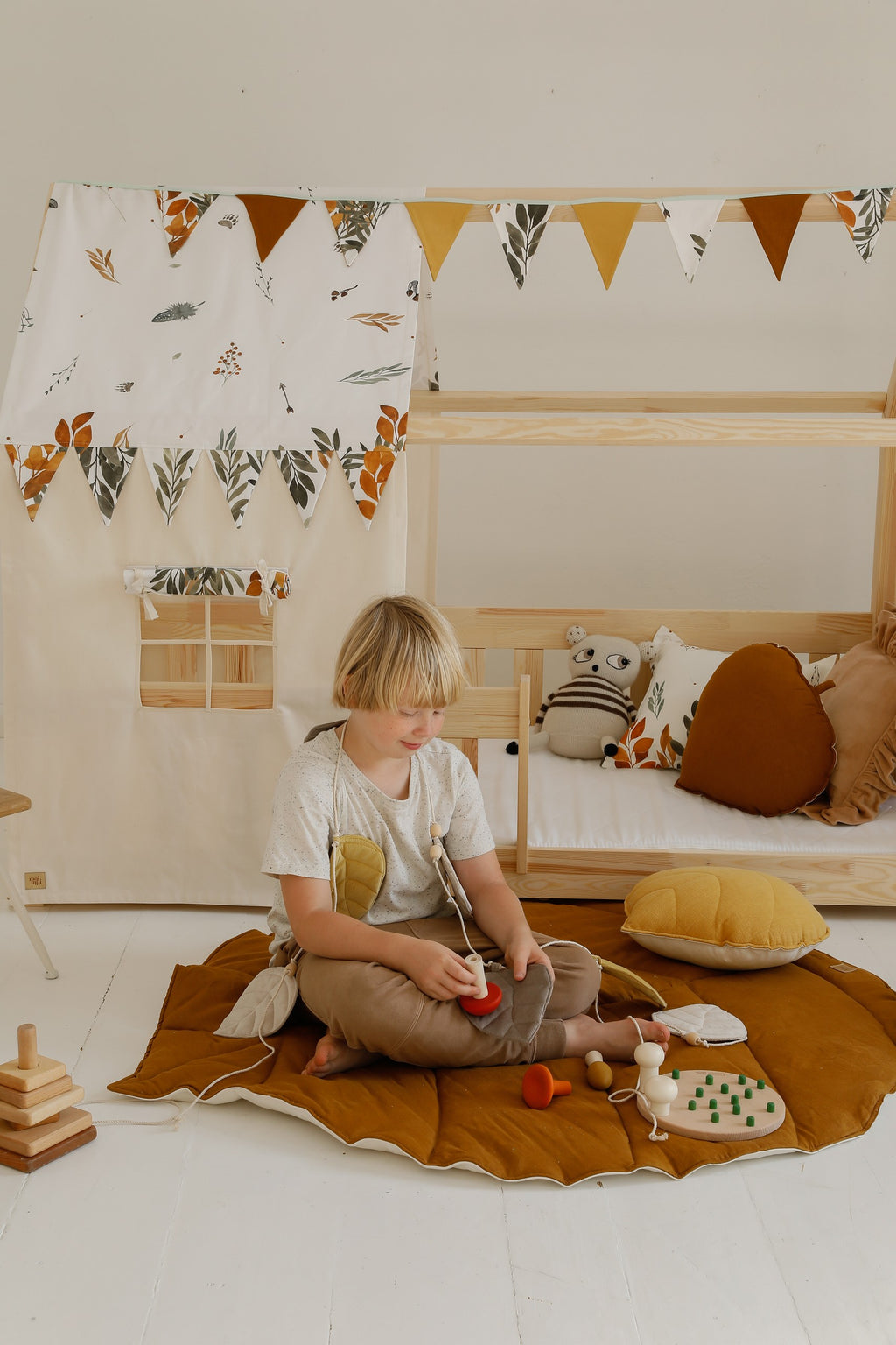 a soft caramel ginkgo leaf playmat on a cozy nursery floor, inviting gentle play