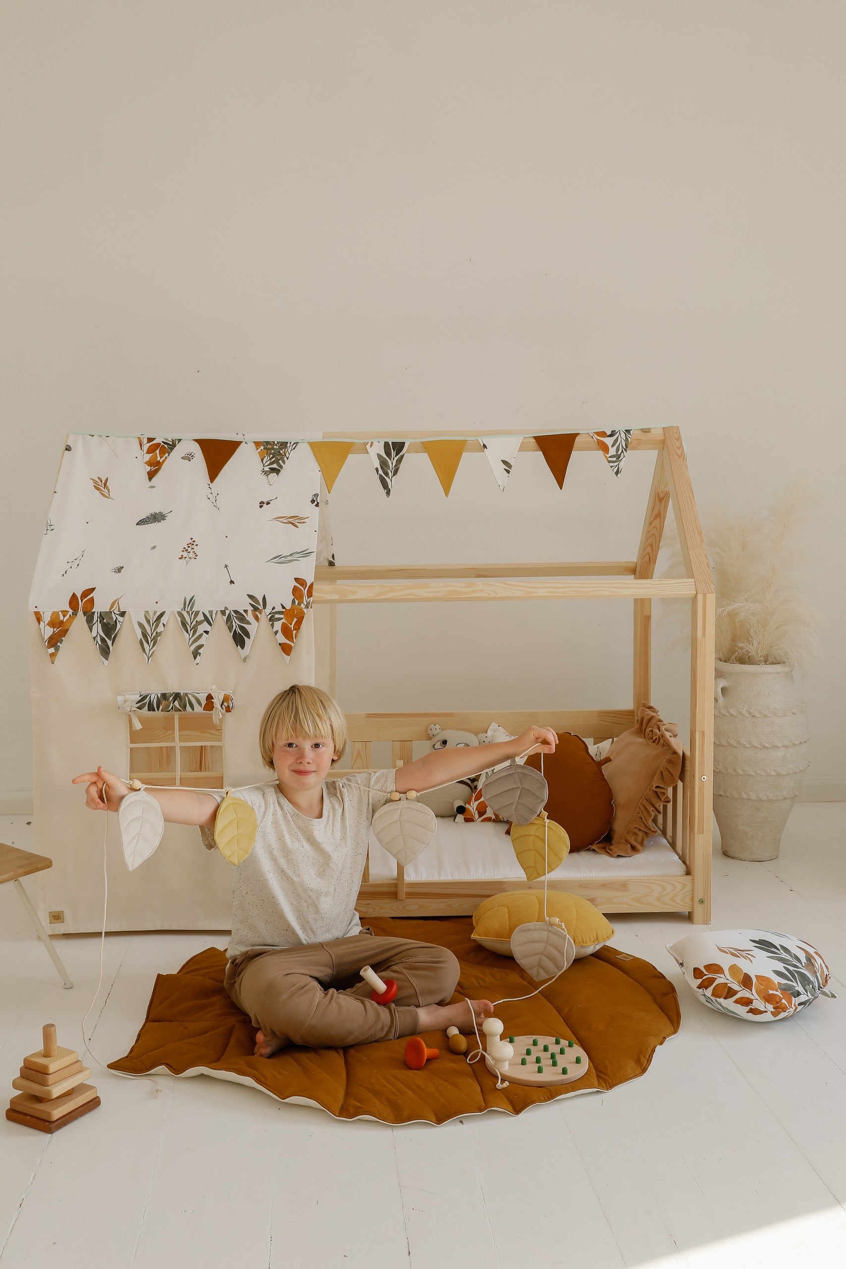 a child having a playful picnic on a soft caramel ginkgo leaf playmat outdoors