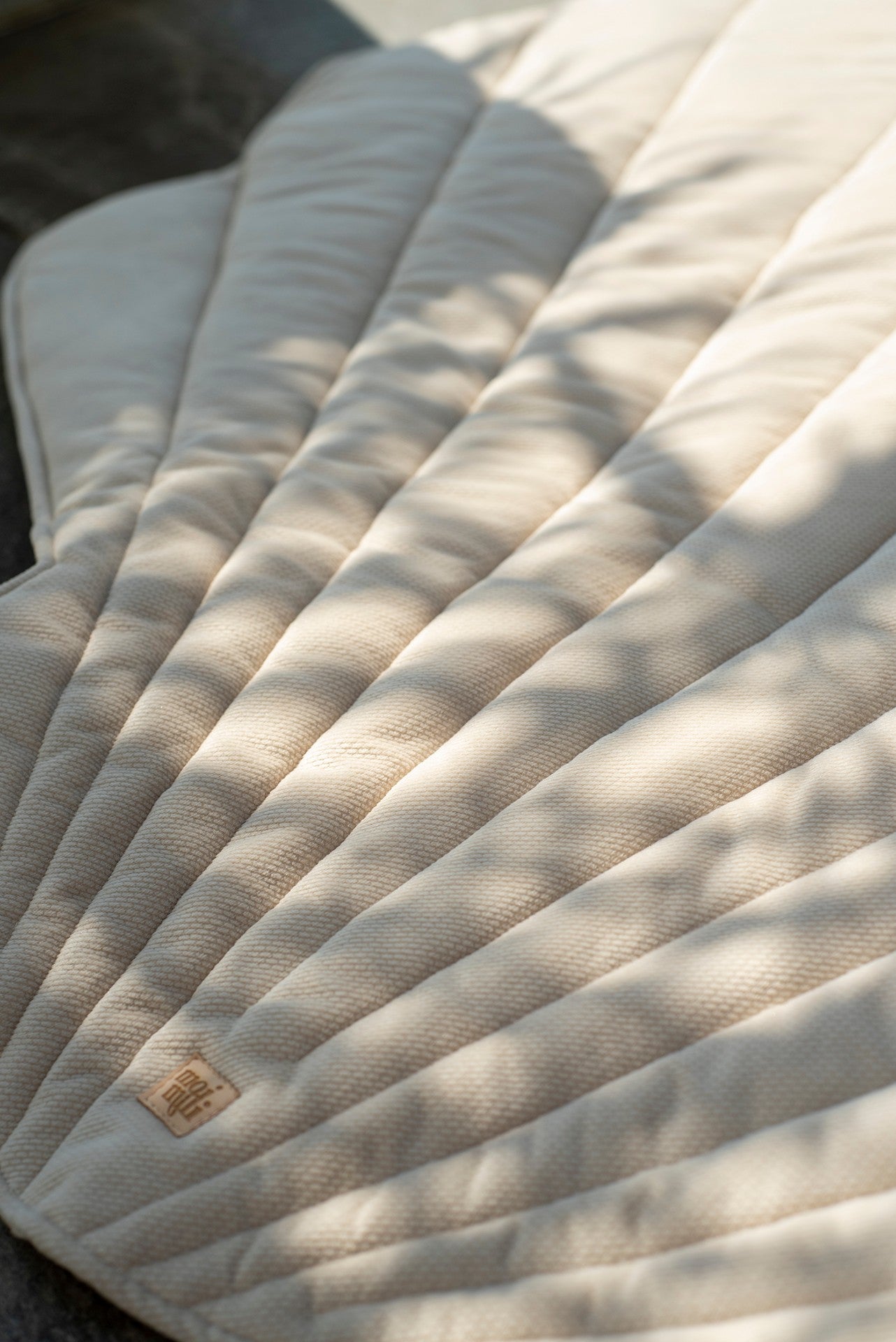 beige organic cotton and velvet ginkgo leaf playmat spread under a tree, soft and inviting for picnics or play