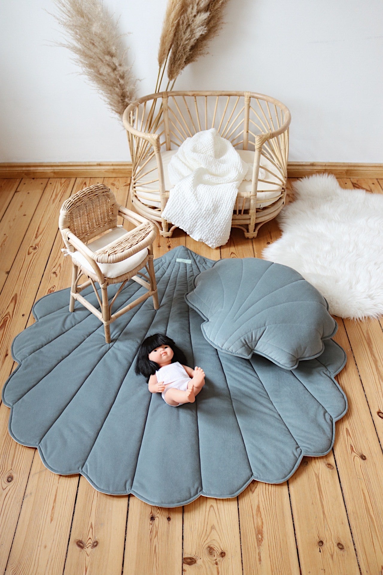 bold blue ginkgo leaf playmat on a dark floor showcasing its vibrant color and plush texture