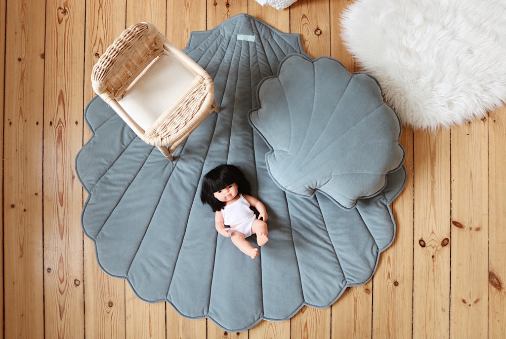 elegant blue ginkgo leaf playmat on a hardwood floor, showcasing its refined handmade polish craftsmanship