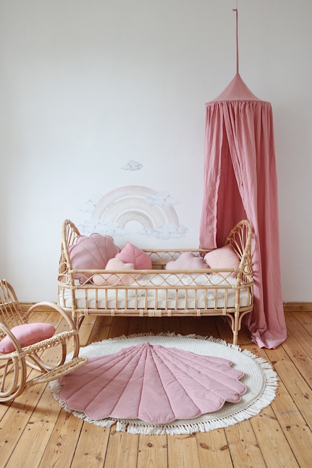 a child's plush pink playmat on a hardwood floor, bathed in soft morning light
