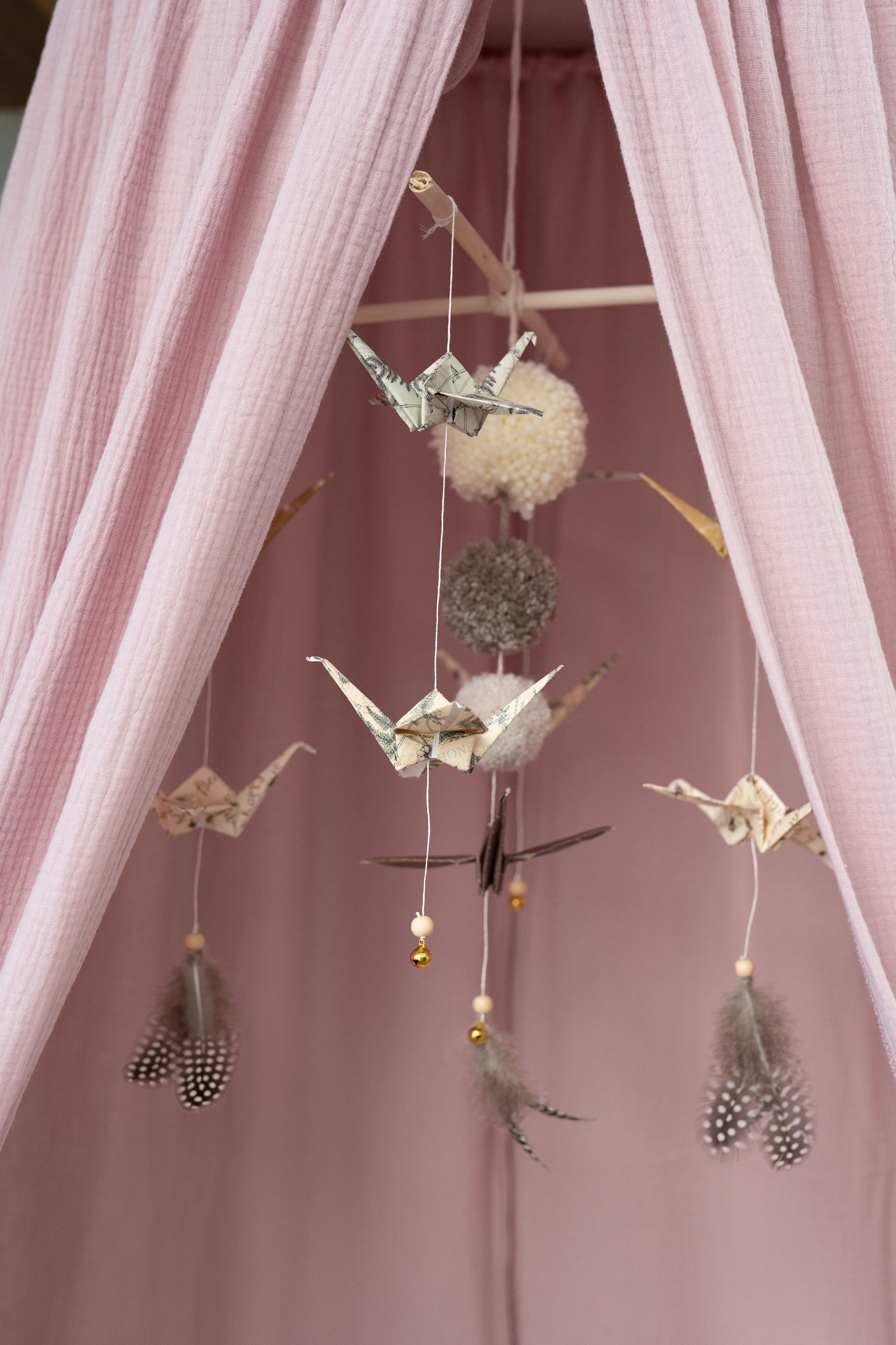 baby pink organic cotton canopy draped playfully over a bed, with soft sunlight filtering through the fabric