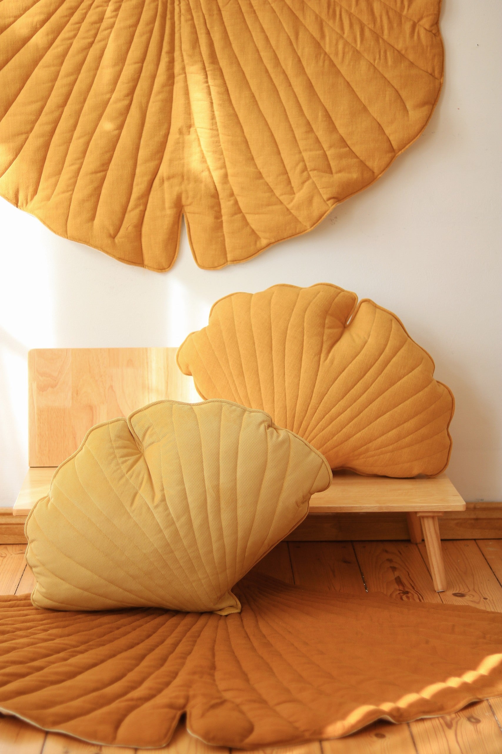 elegant ginkgo leaf playmat in mango, showcasing its artisanal stitching and refined texture in natural light