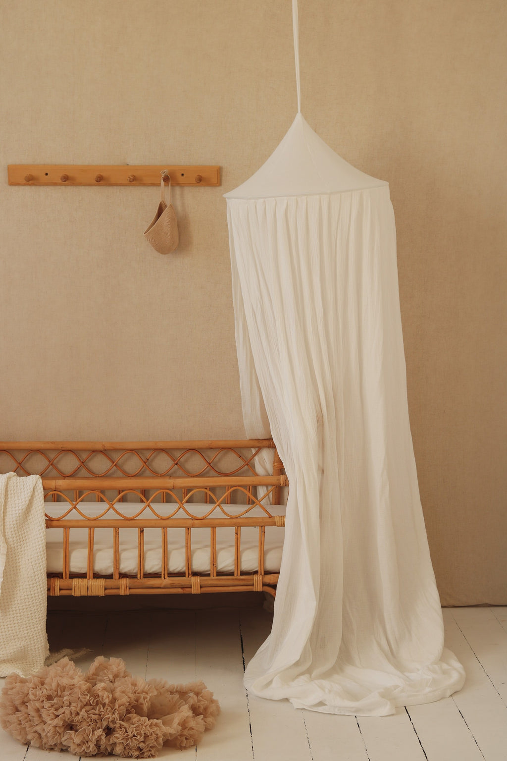 cream cotton canopy draped over a bed with soft sunlight filtering through, creating a cozy hideout