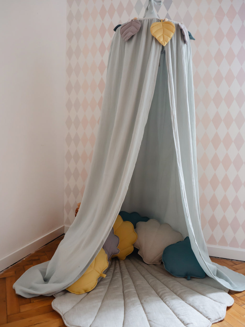 elegant mint organic cotton canopy hanging in a softly lit nursery, showcasing its refined handmade craftsmanship