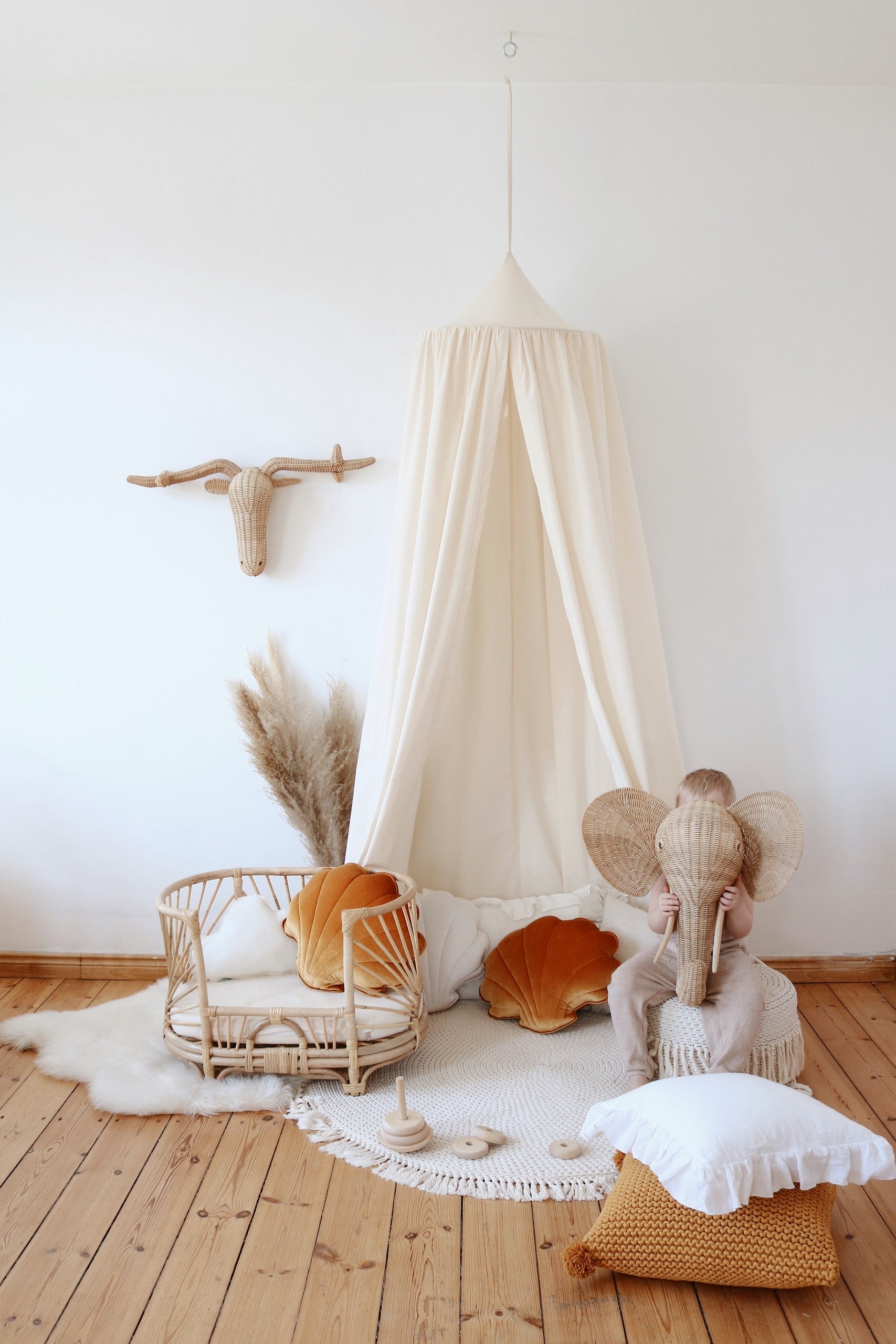 organic cotton canopy draped over a bed with soft morning light, creating a cozy hideaway for quiet moments