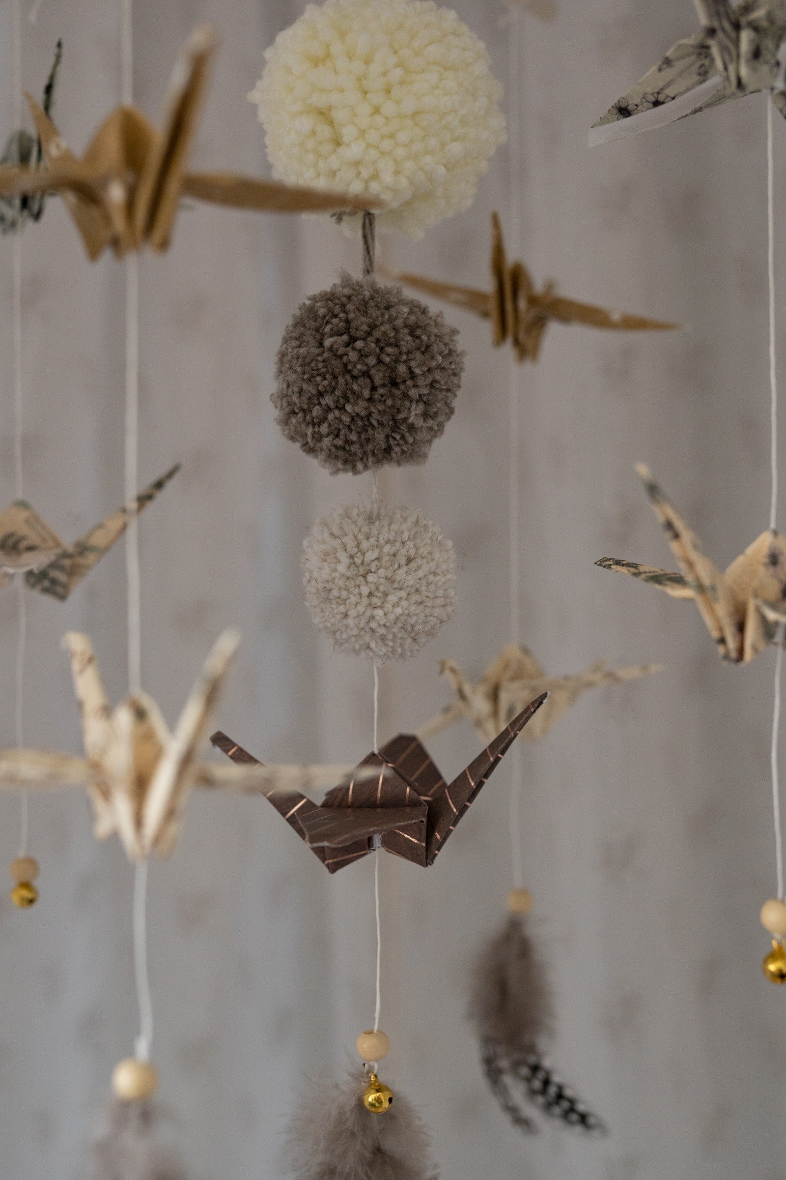 gold dust origami mobile in a minimalist nursery with soft morning light highlighting the delicate paper cranes