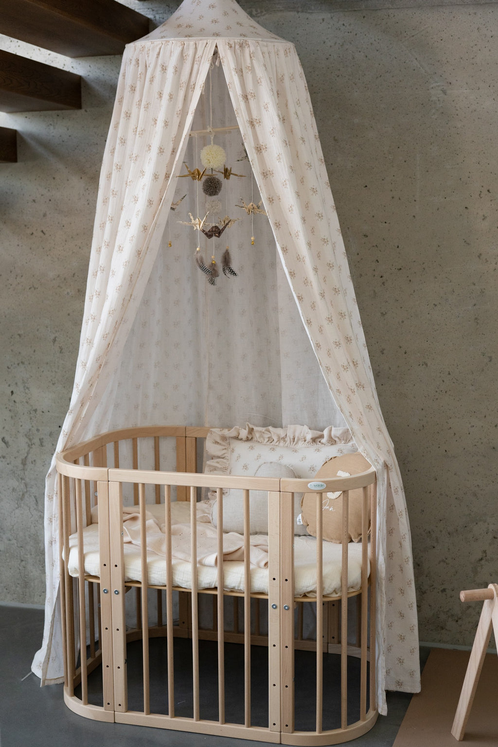 elegant gold dust origami mobile in soft morning light above a minimalist nursery crib