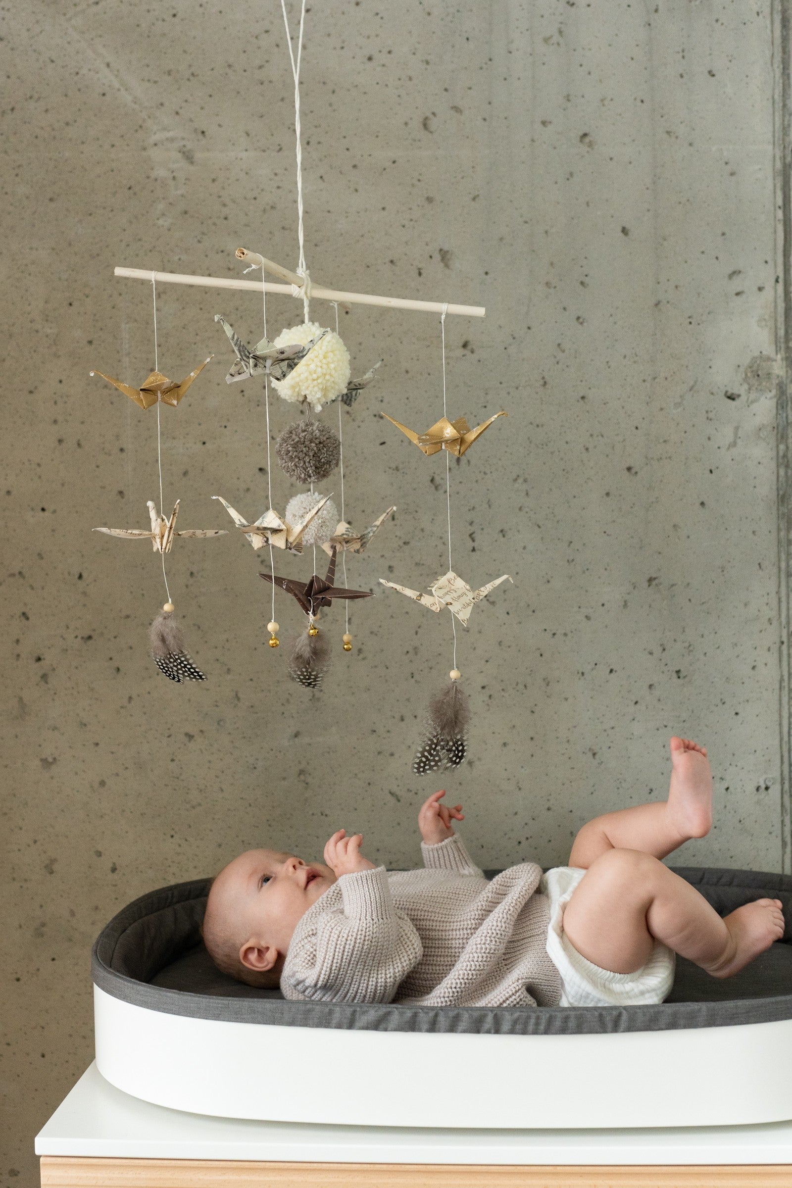 bold gold dust origami mobile in dramatic low-angle shot above a modern crib