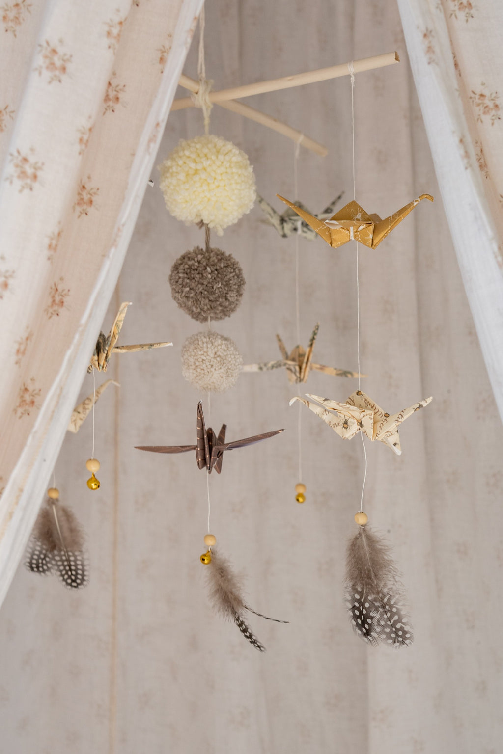elegant gold-dusted origami mobile in a minimalist nursery with soft morning light