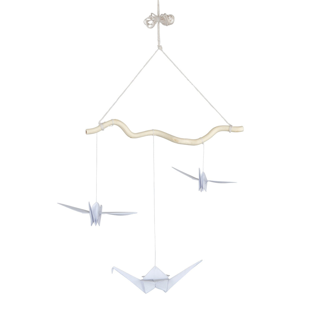 elegant handmade origami mobile with white paper cranes and soft pompoms against a minimalist backdrop