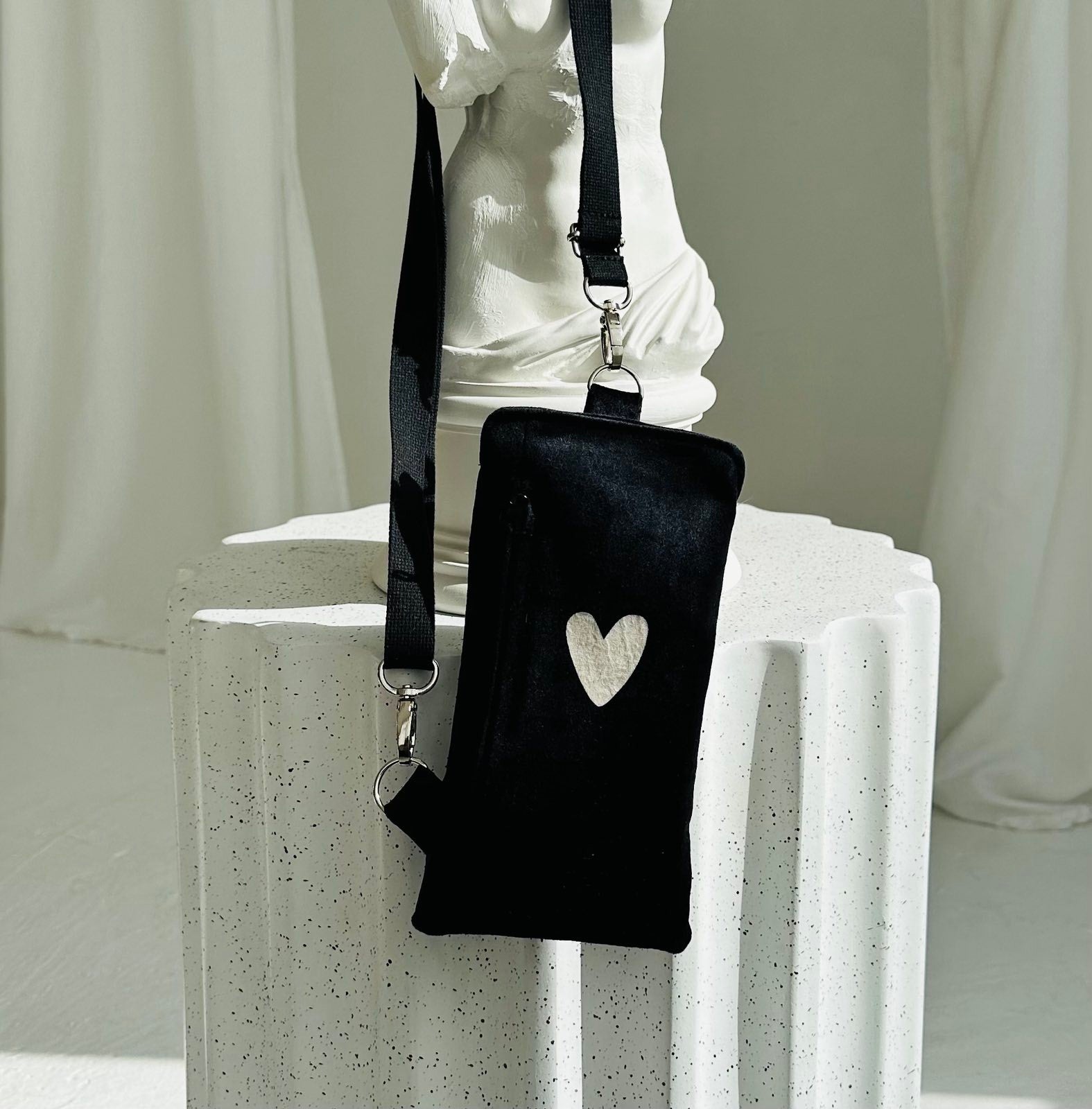soft black velour heart phone bag with a cozy texture and adjustable strap for comfortable wear