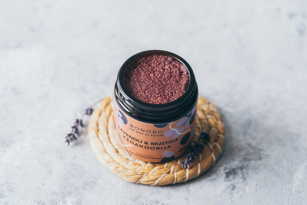 a contemporary craft leather gift box open to reveal four vibrant natural body scrubs