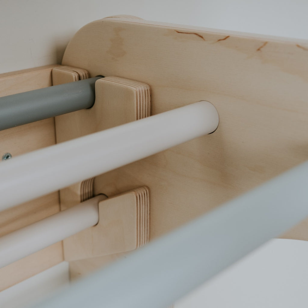 a sophisticated pastel climbing set arranged in a sunlit, minimalist living room