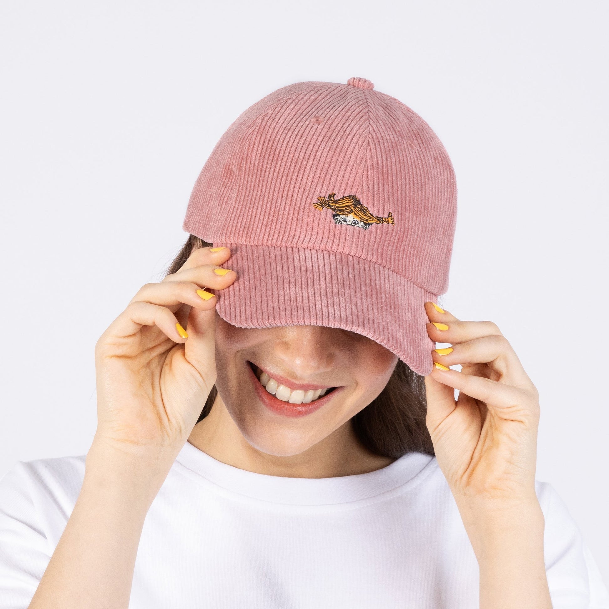a bold, close-up shot of a vibrant pink pippi corduroy dad cap on a model, radiating confident, rebellious energy