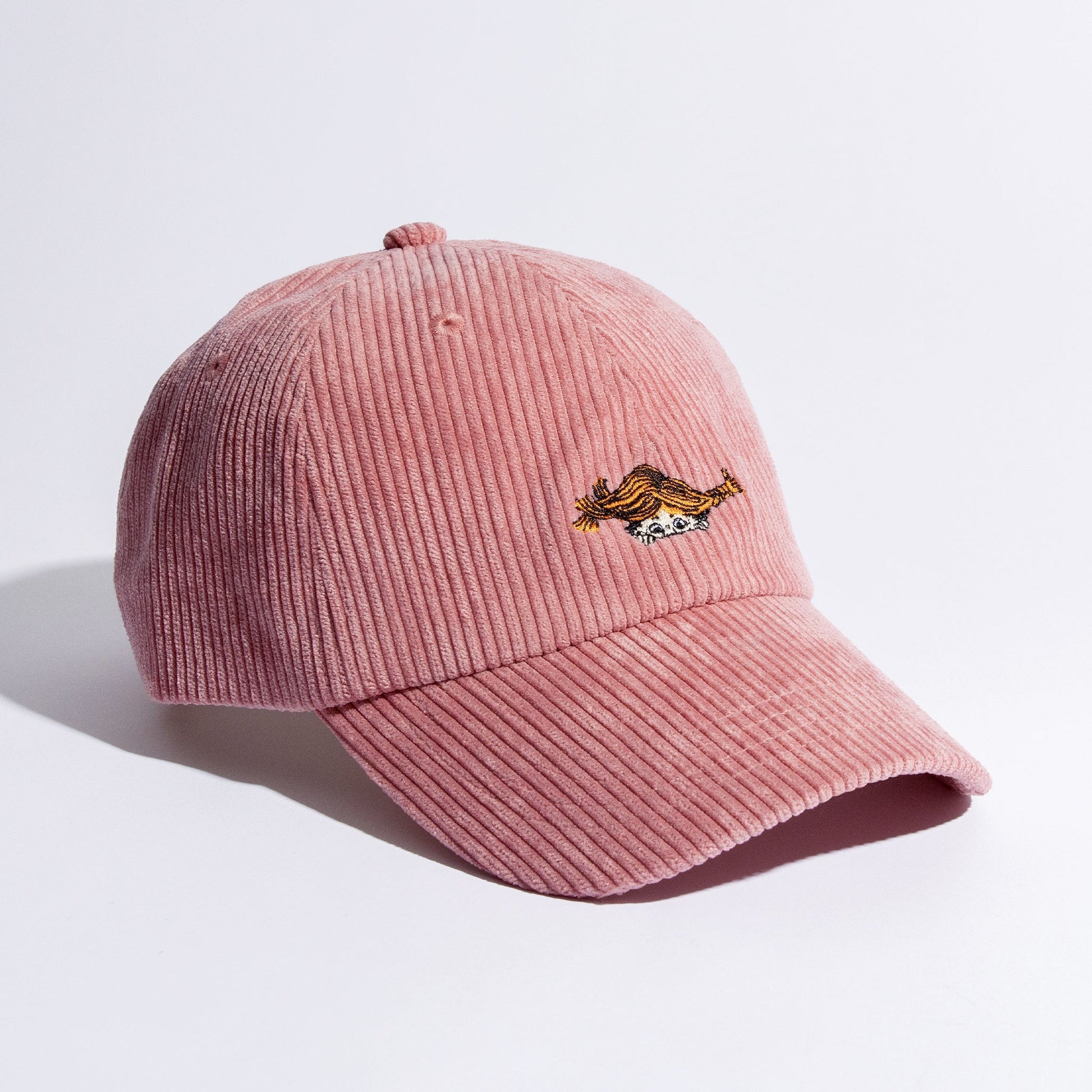 a playful pink corduroy dad cap tilted on a sunny windowsill, embodying pippi longstocking's fun spirit