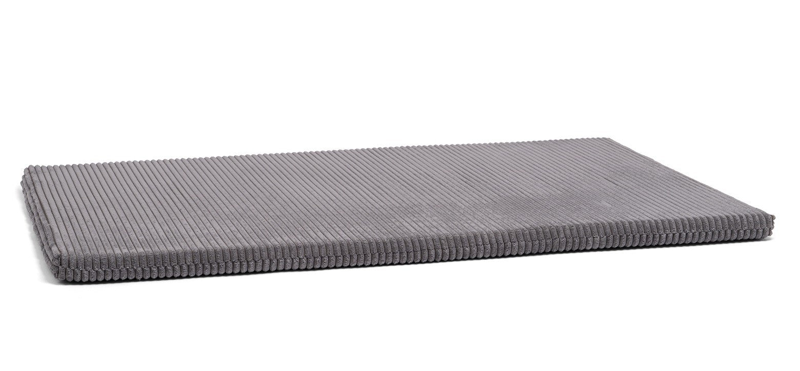 a child playing on a soft mint green foam play mat in a sunlit room