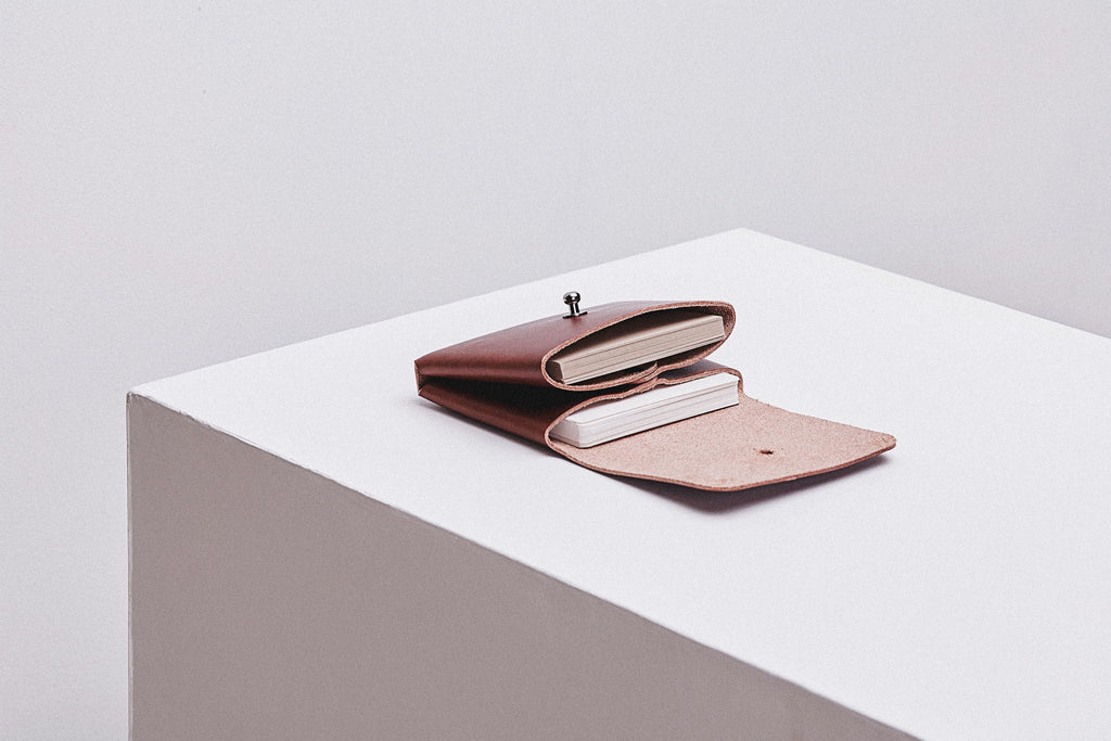 elegant minimalist deep pouchie wallet in soft italian leather, shown open to reveal its dual compartments