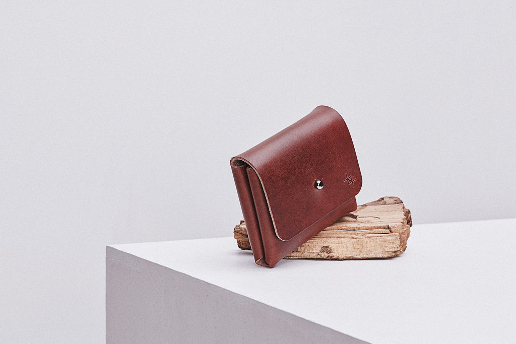 close-up of minimalist deep pouchie wallet in warm natural light on a rustic wooden table