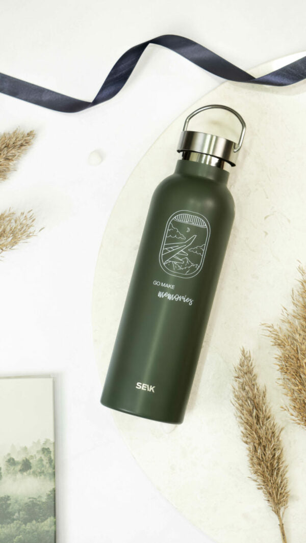 a soft-lit 500ml thermos resting on a mossy log, its sleek design promising reliable hydration on a peaceful trail