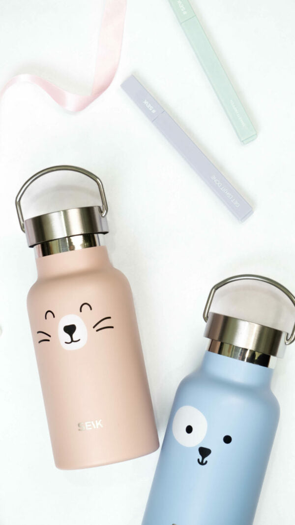 a soft-focus shot of the adorable cat water bottle held gently in a child's hands