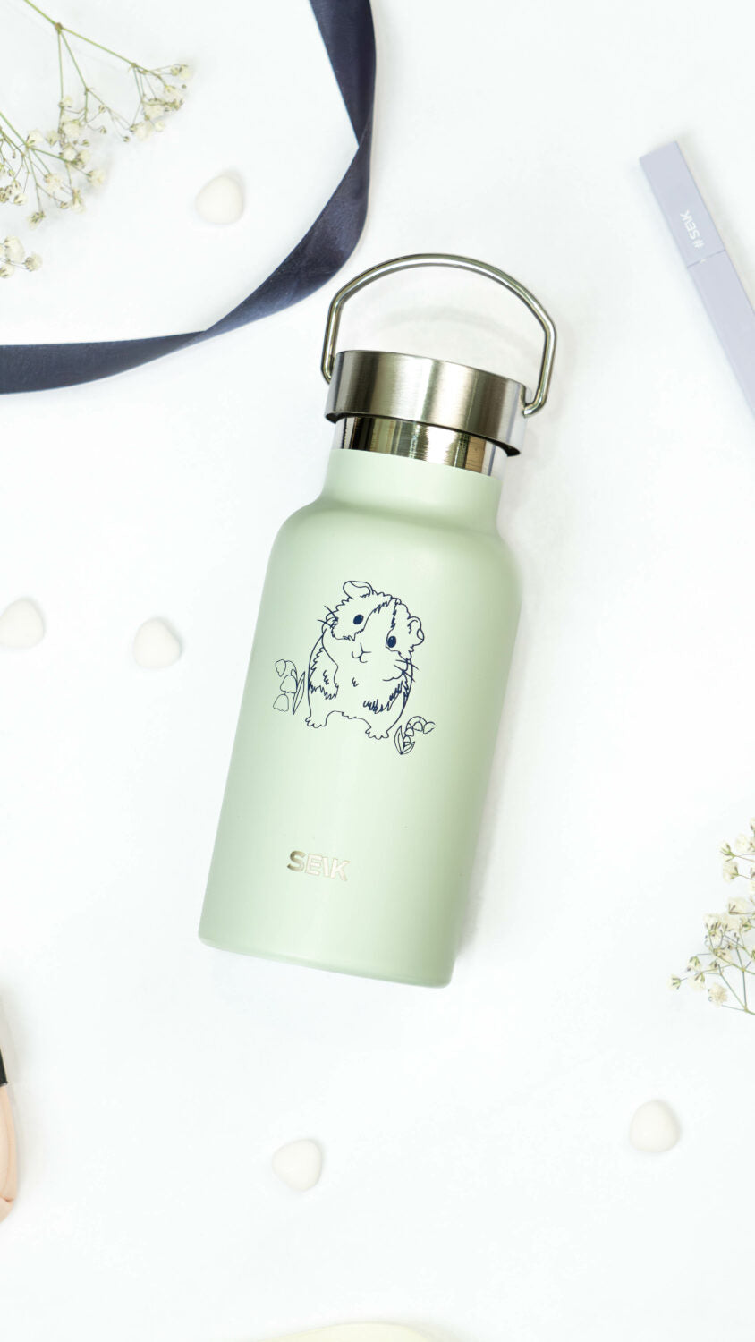 elegant light green guinea pig thermos on a marble surface, showcasing its sophisticated and leakproof design