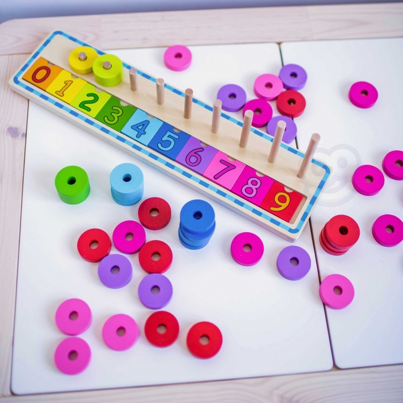 close-up of a child's hands placing a vibrant yellow circle on the wooden counting puzzle board
