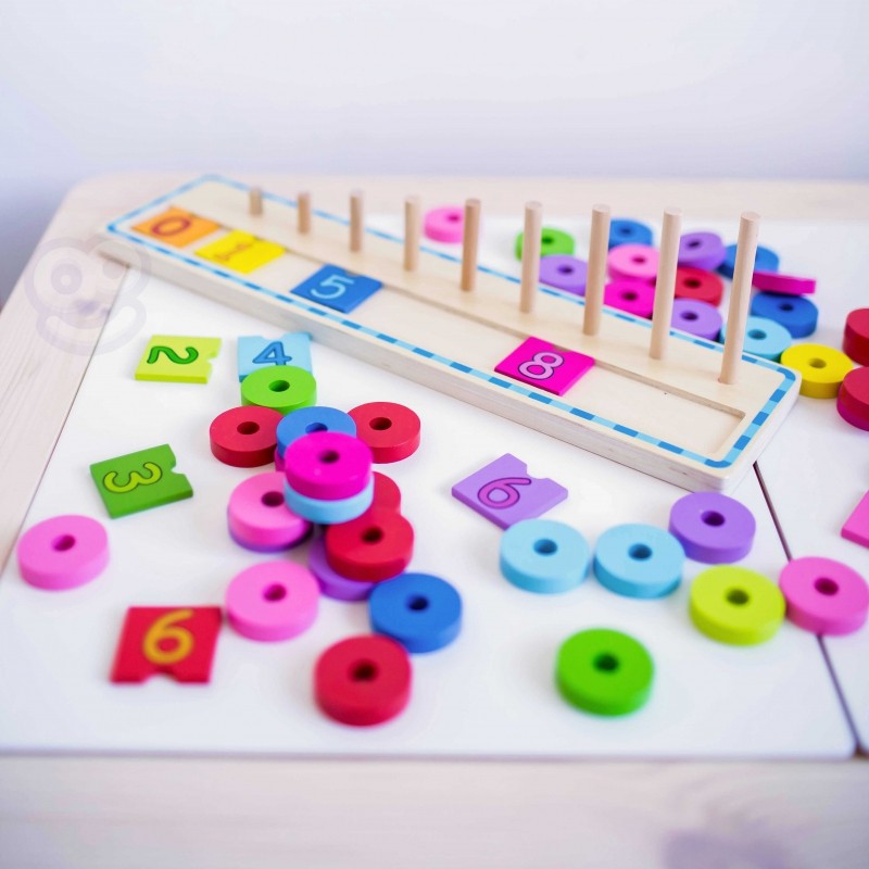 close-up of a toddler's hand placing a vibrant green counting puzzle piece