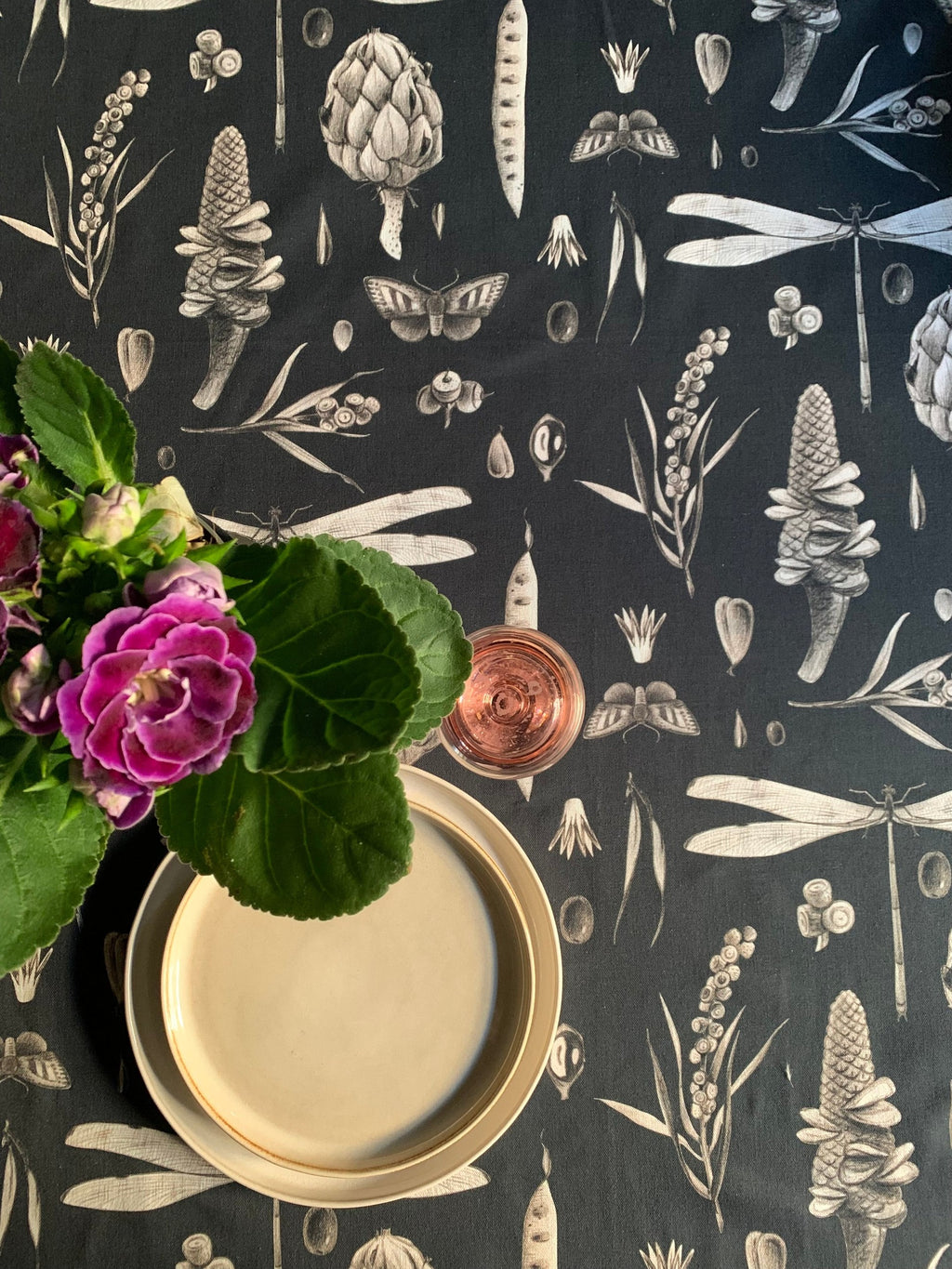 a soft cotton tablecloth with a subtle seeds carbon print, laid gently on a table in warm morning light