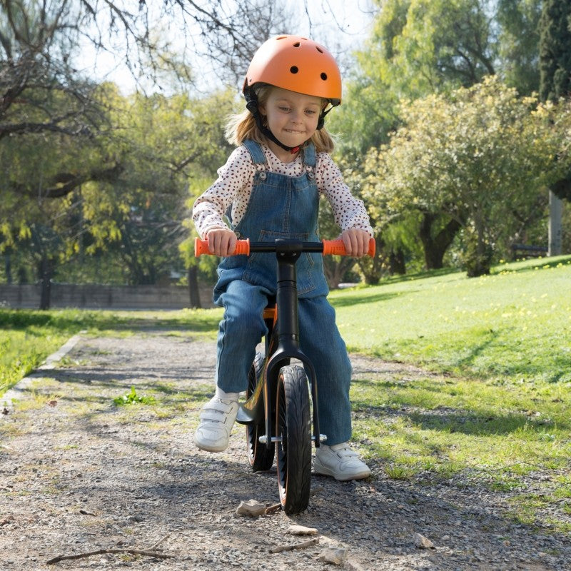 toddler adjusting the seat height on a lightweight blue balance bike indoors