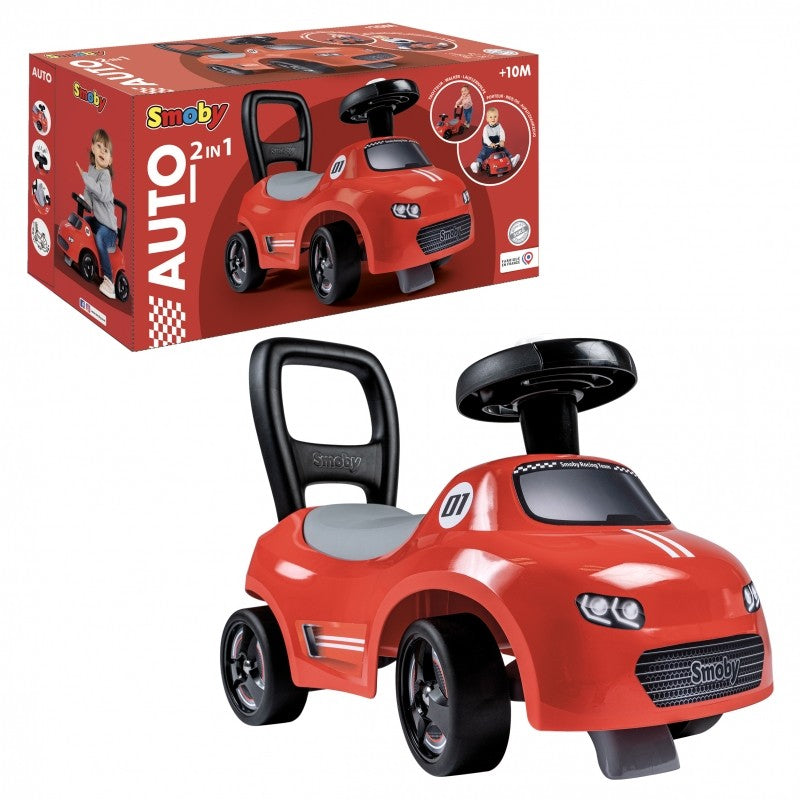 a happy toddler beeping the horn of their bright red smoby ride-on car indoors