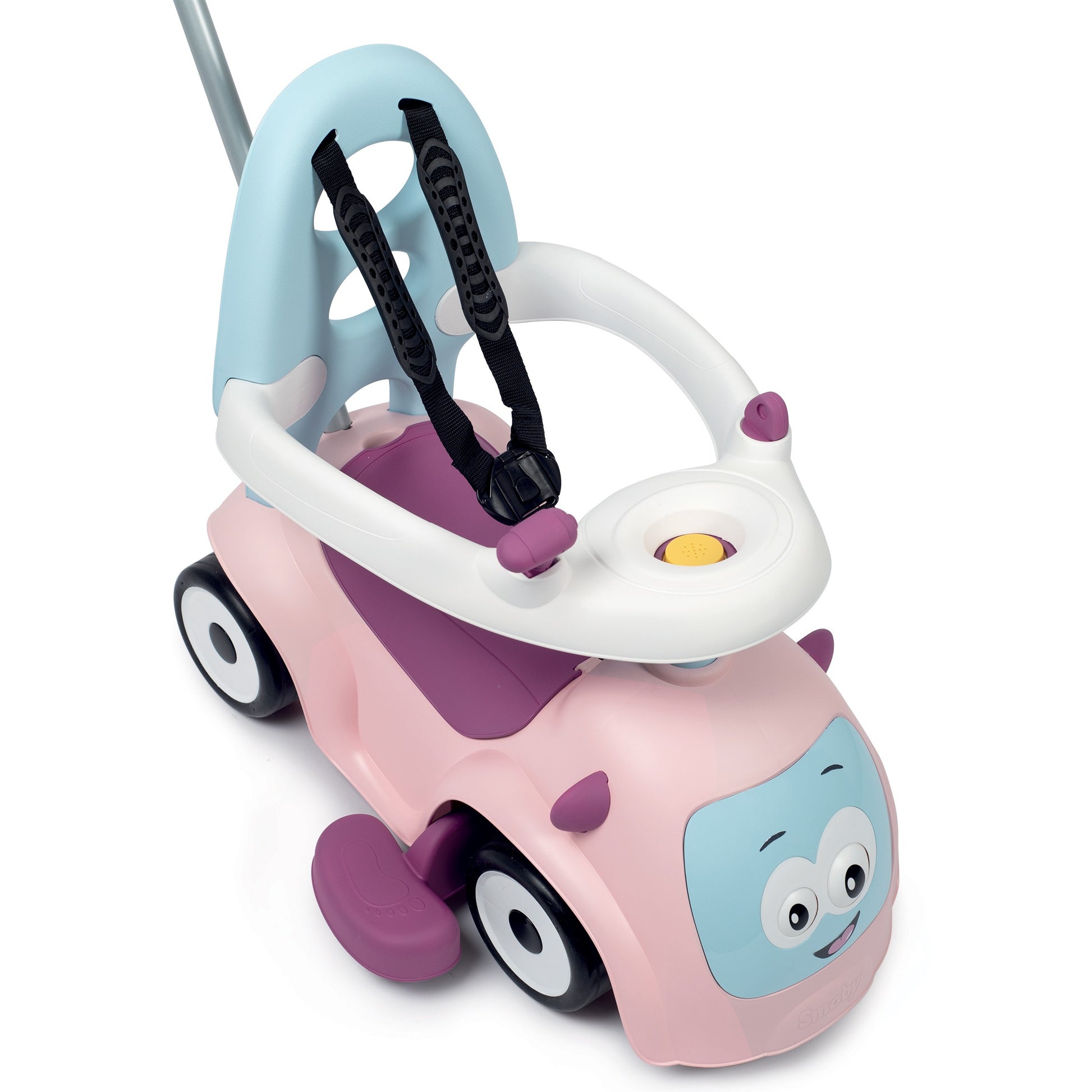 a smiling toddler playing with the pink maestro 3in1 ride-on's interactive horn and wobbly eyes