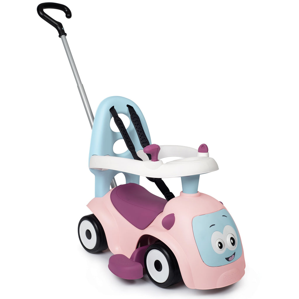 a child playing with the pink maestro 3in1 ride-on toy in a sunlit garden