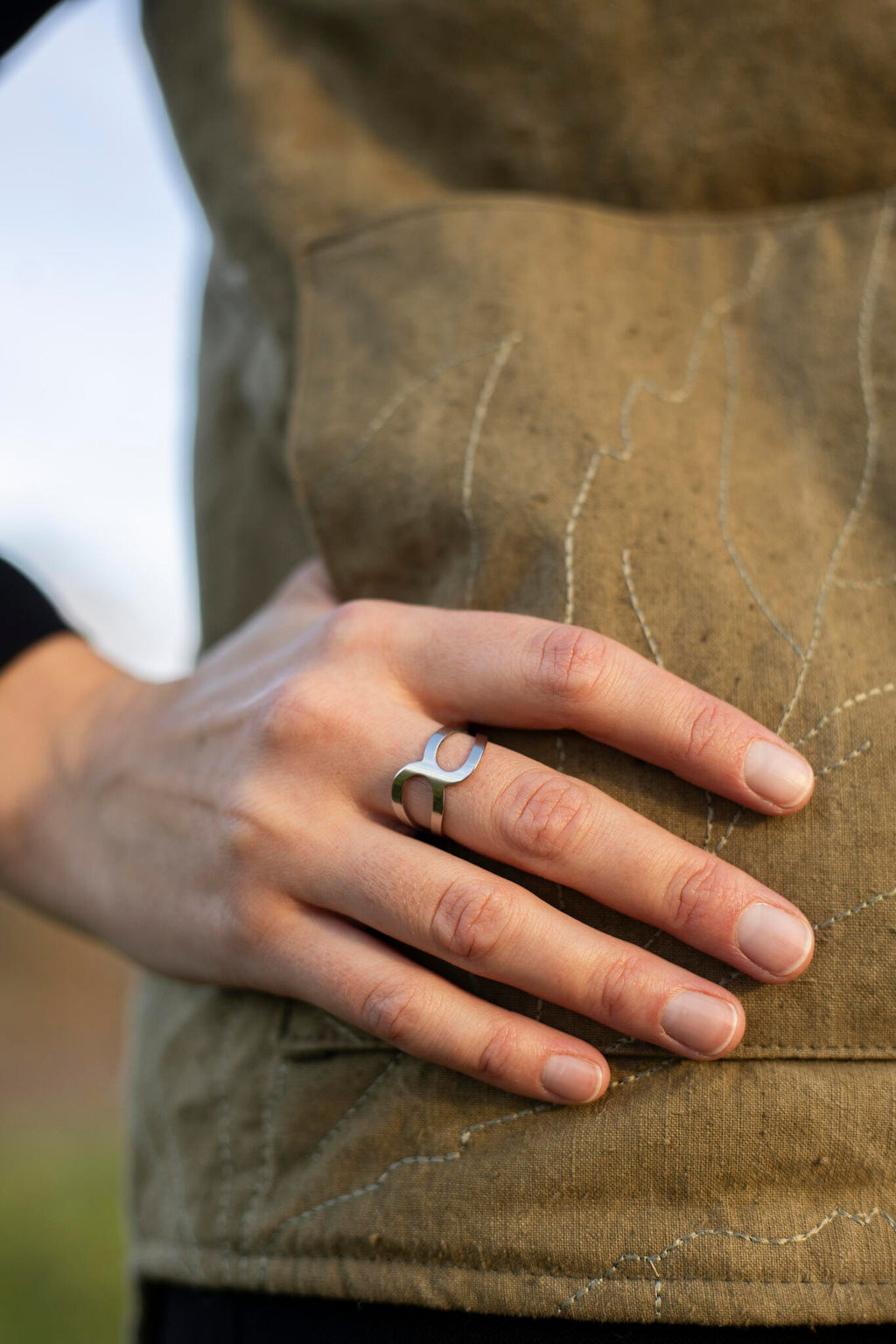 a soft-focused close-up of the polished stainless steel ring x resting on a cozy velvet surface