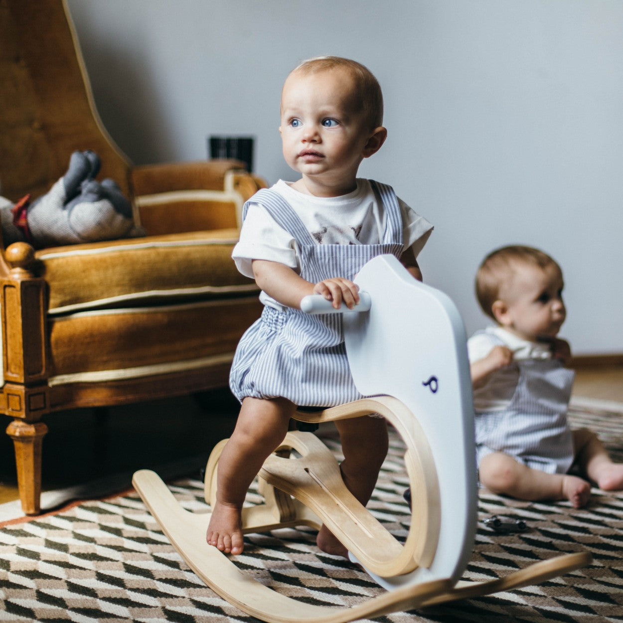 a soft-lit close-up of the wooden rocking elephant base, showing its gentle curves and smooth, non-toxic finish for a baby's first ride.