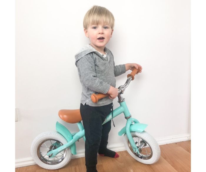 confident toddler on a marshall balance bike with 10-inch air tires on a sunny path