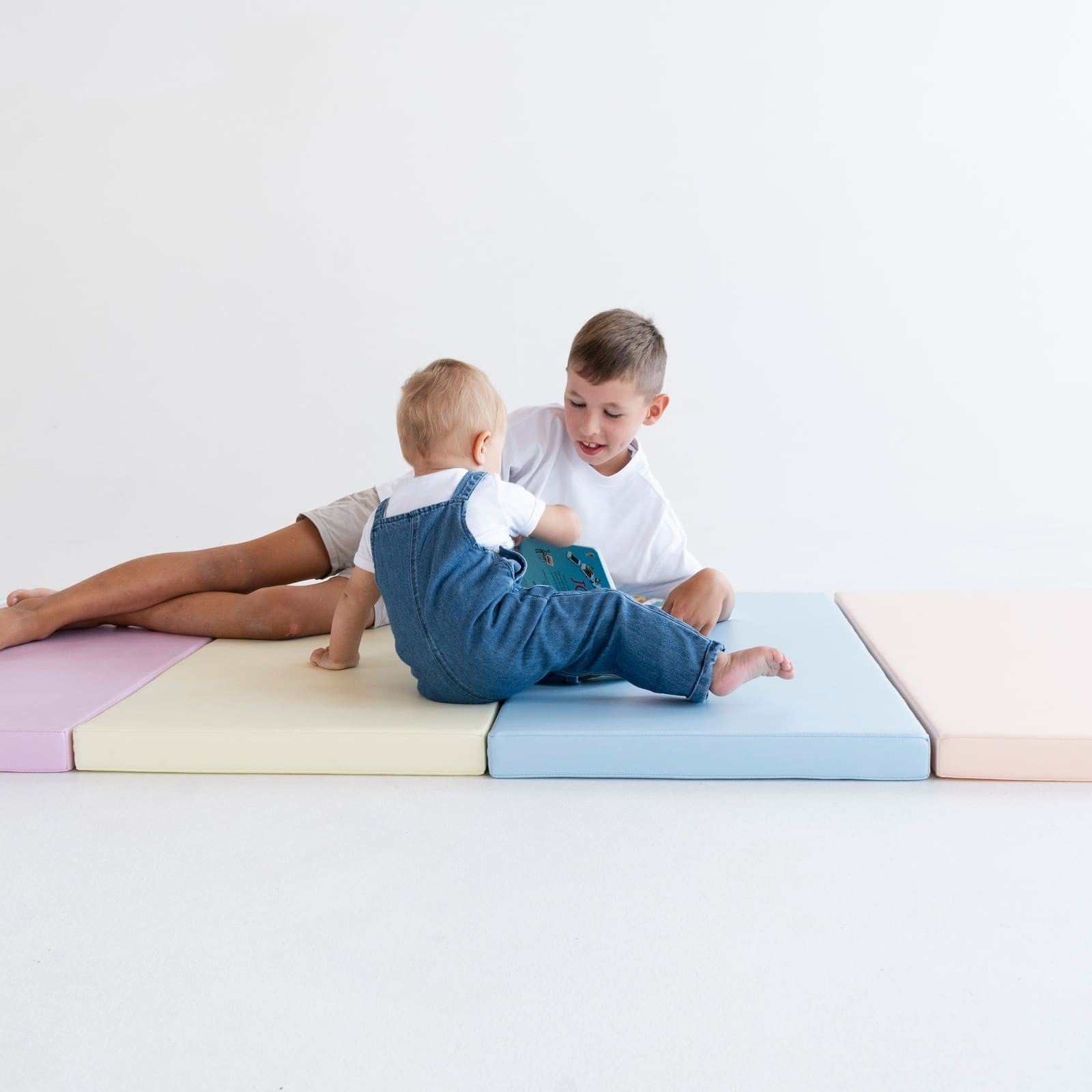 a playful arrangement of pastel iglu play mats in a sunny nursery corner