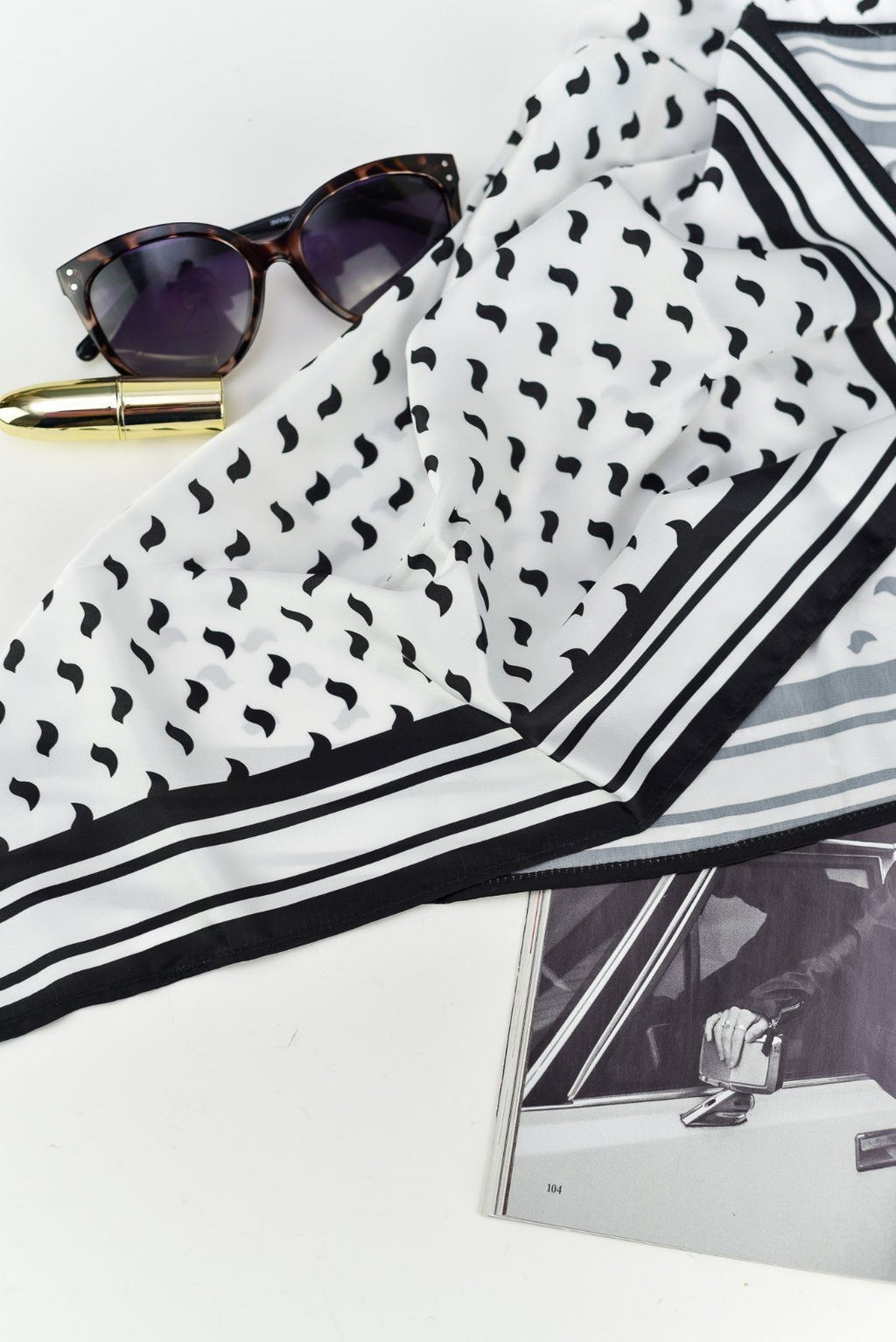 playful close-up of a black bird scarf tied in a fun, summery hair wrap