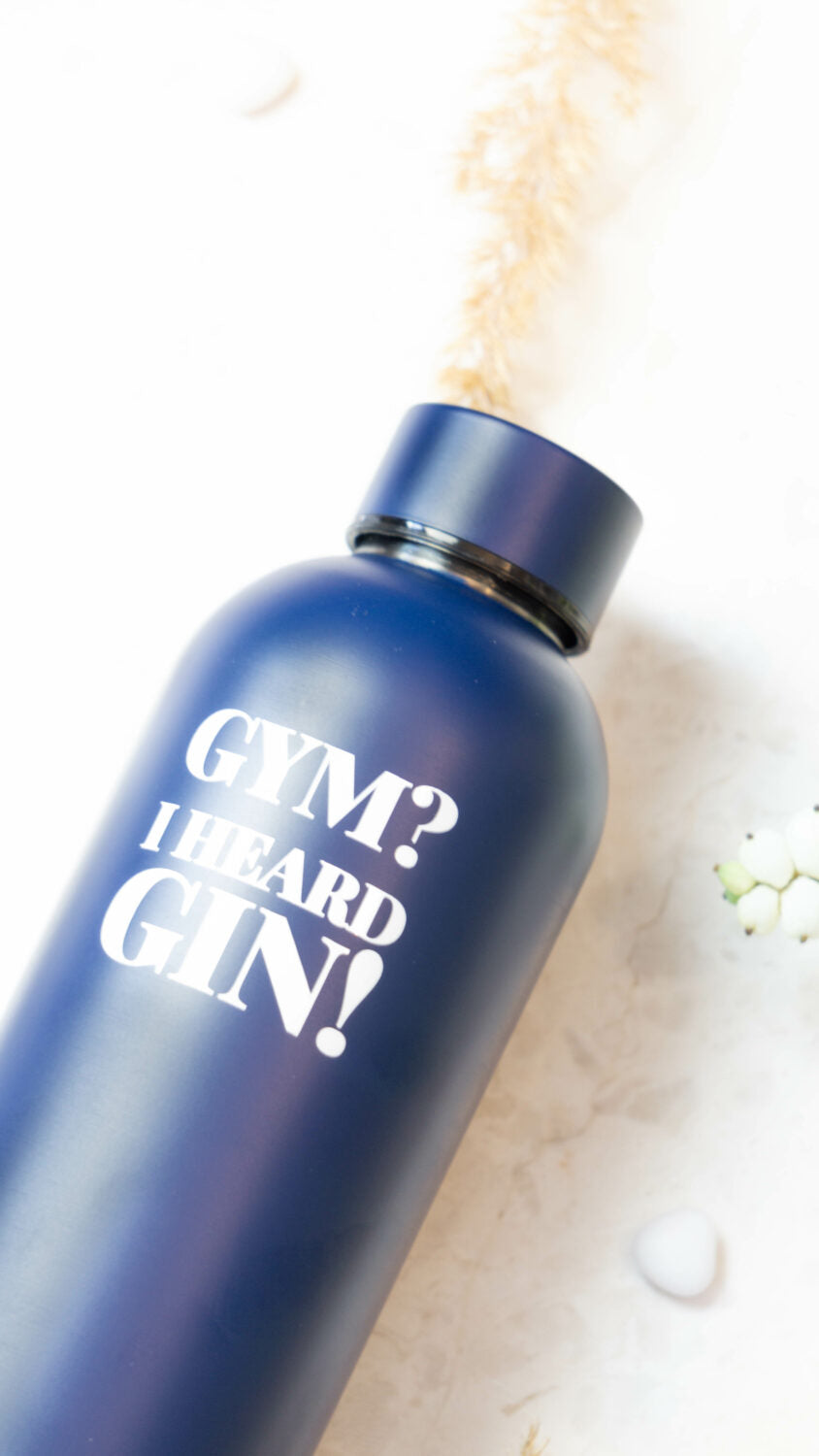 a playful dark blue thermos with 'gym? i heard gin!' slogan on a vibrant bar cart