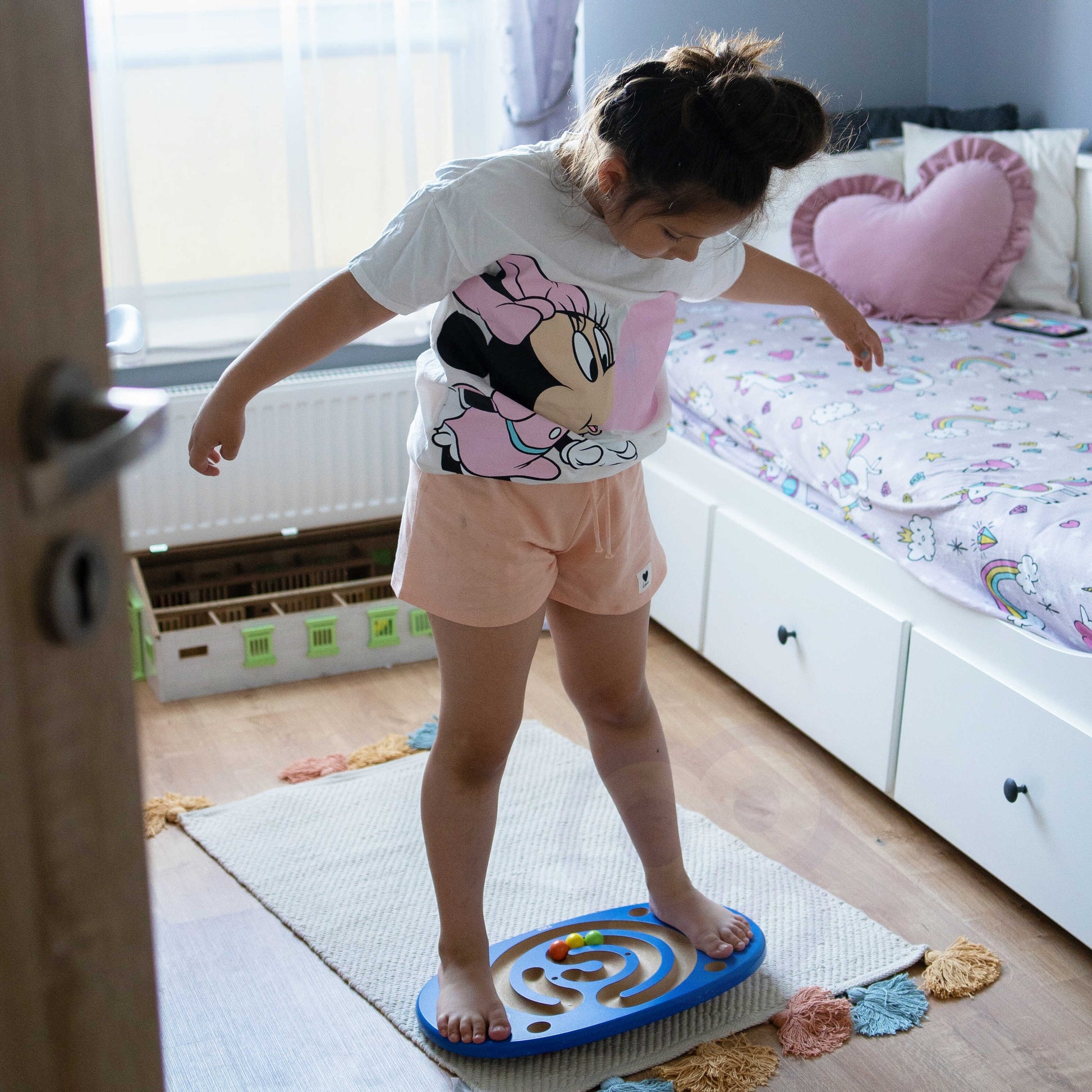 playful wooden balance board with maze, child laughing while guiding a red ball through the wavy path