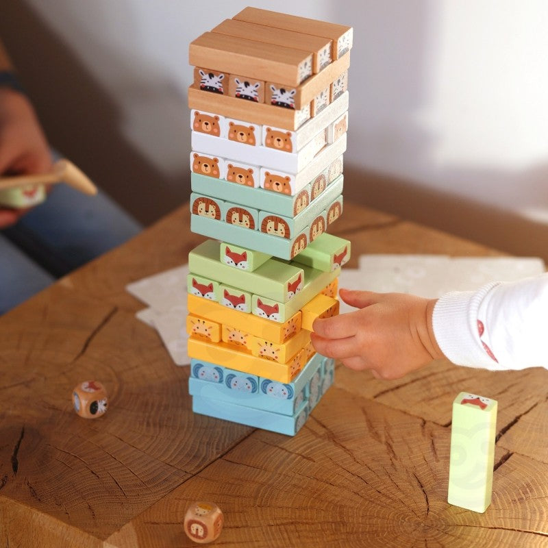 playful toddler stacking soft pastel wooden blocks from the shaky tower game