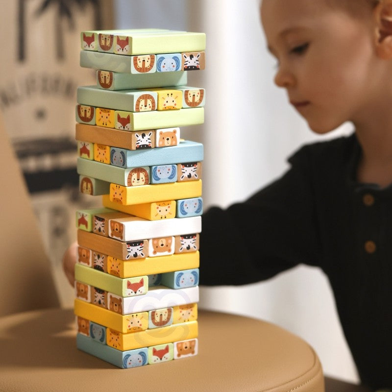 close-up of a child's hands carefully placing a pastel wooden block on the shaky tower