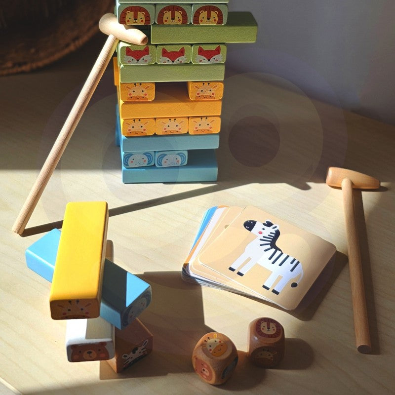 close-up of a child's hands stacking soft pastel wooden blocks from the shaky tower game