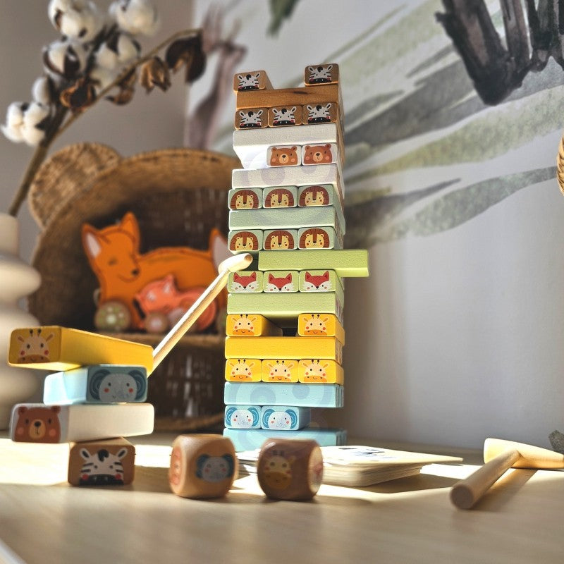 close-up of a child's hands carefully placing a pastel wooden block on the shaky tower game