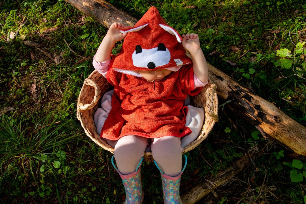 soft bamboo fox poncho for kids in gentle morning light, side view showing cozy hood and pockets